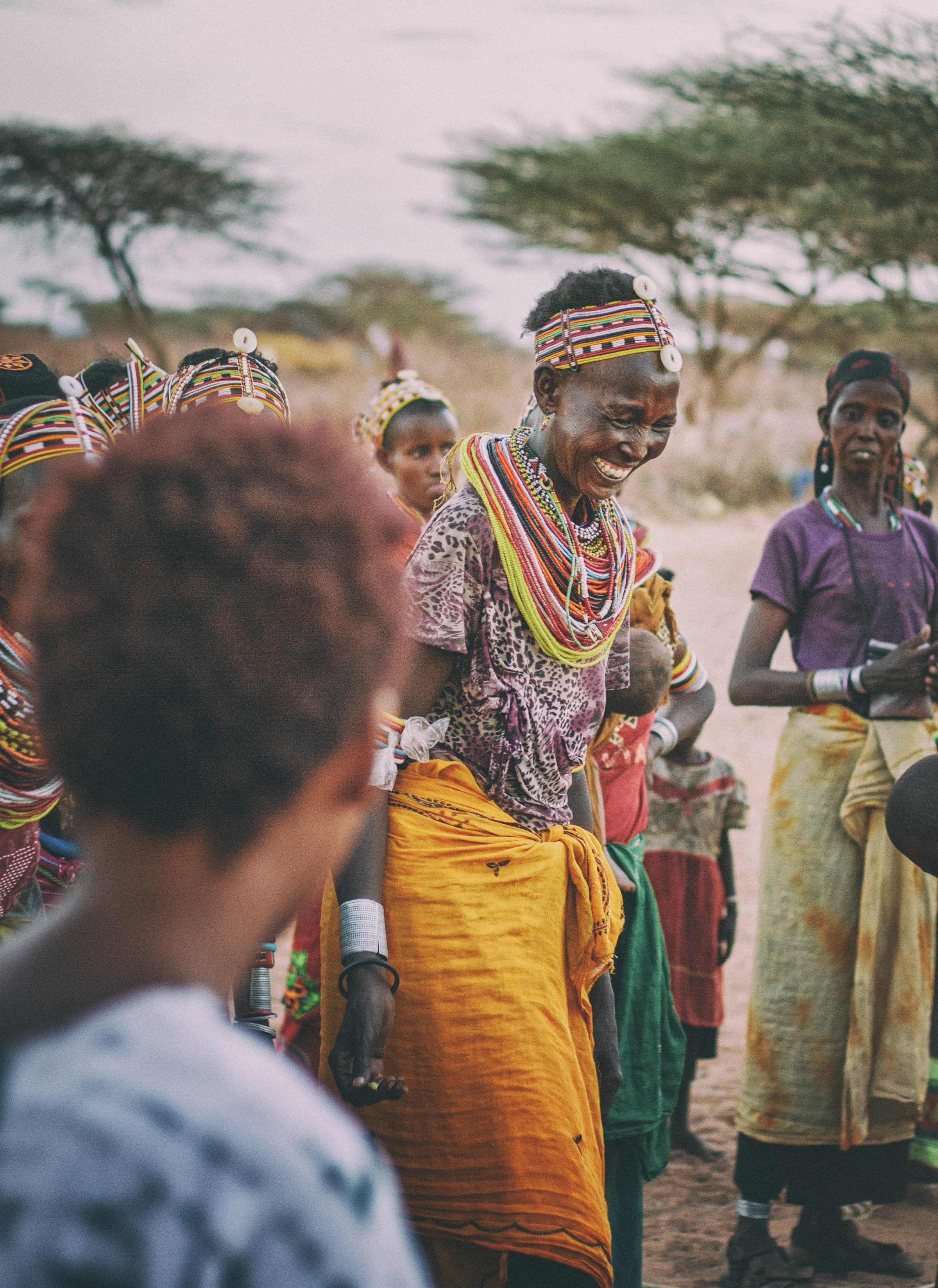 A woman dances among community members during a daytime gathering in Kargi, Kenya.